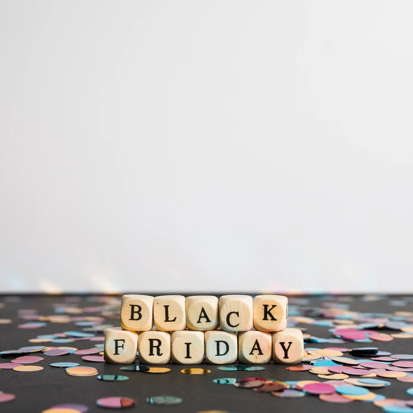 Надпись «Black Friday» на кубиках на черном столе.